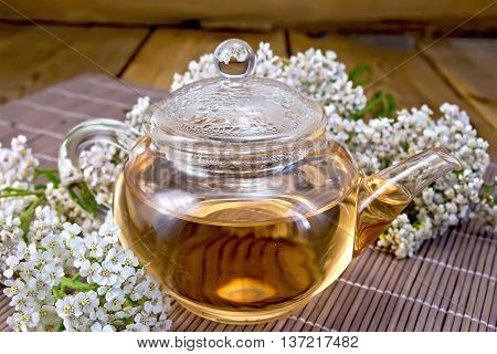 Tea With Yarrow In Glass Teapot On Bamboo