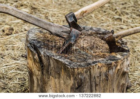 Axe stuck in treeold axe stuck in a stump on a background of straw closeup
