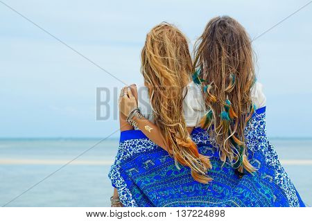 Two beautiful boho girls watching the hotizon