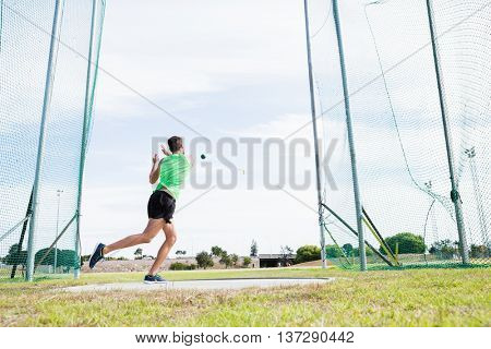 Athlete performing a hammer throw in stadium