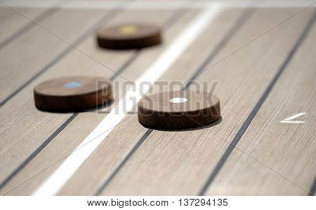 Shuffleboard game on the wooden deck of a cruise ship