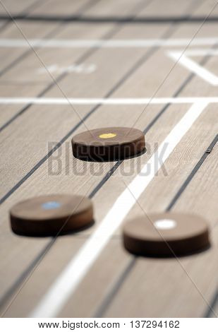 Shuffleboard game on the wooden deck of a cruise ship