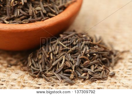 Caraway seeds in a bowl on jute