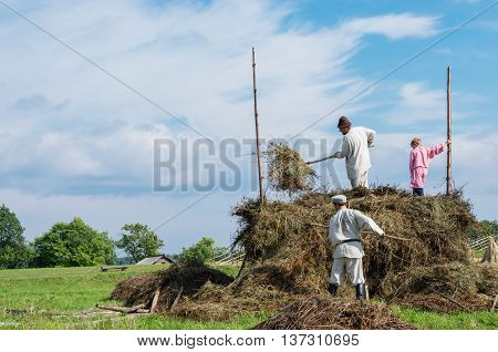 KIZHI RUSSIA - AUG 07 2015: People in national costumes work in the field on the island Kizhi Rusia