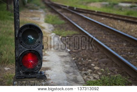 Red semaphore near railway in a developing country. Soft focus.