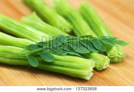 Medicinal moringa oleifera with leaves on wooden surface