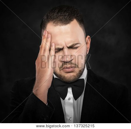 Young man holding his head feeling a headache or intensely thinking.