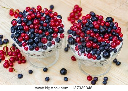 Dessert with cream and fresh berries (red and black currants, blueberry)