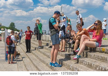 DNEPR UKRAINE - June 25 2016:Group of positive young people having rest on the Dnepr river embankment at June 25 2016 in Dnepr Ukraine