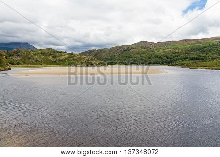 View of the River Dwyryd near Penrhyndeudraeth. Sand bank trees and rocky hills. Gwynedd Snowdonia Wales United Kingdom.
