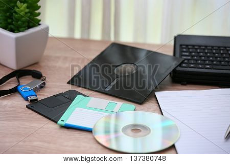 desk with note ,floppy disk A, floppy disk B and memory drive in home office, private office and modern desk in modern life, online market and planning for work, document and paper on desk.