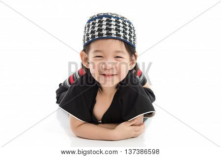 Cute muslim chlid lying on white background isolated.