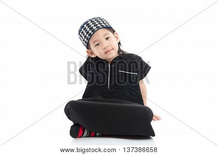 Cute muslim chlid sitting on white background isolated.