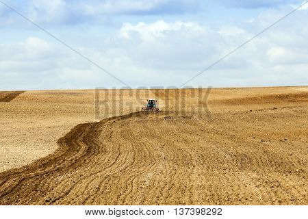 an old tractor plowing the field before sowing. spring season. heaven