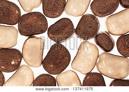 Slices of black rye bread and white bread on a white background. Food background. Pattern.