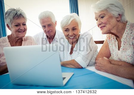 Group of seniors using a computer in the retirement house