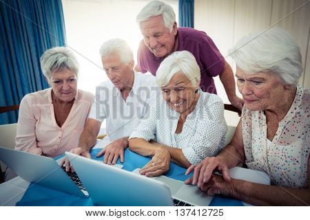 Group of seniors using a computer in the retirement house