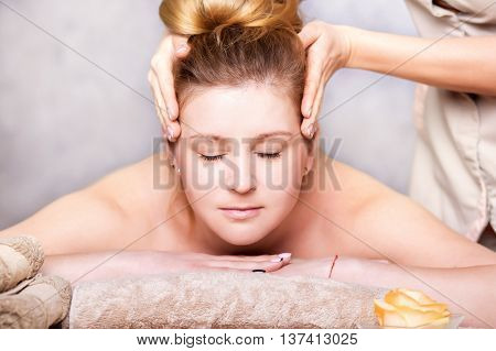 head Massage. Closeup of a Young Woman Getting Spa Treatment.