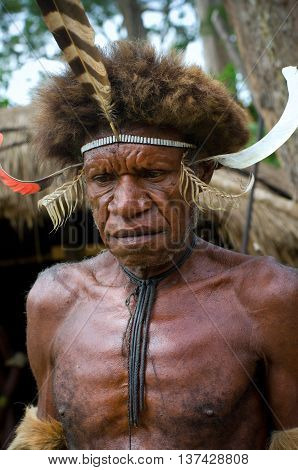 Warrior Of A Papuan Tribe In Traditional Clothes