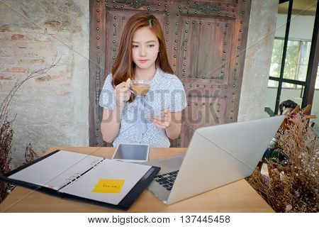 Beautiful business woman using a laptop computerAnd drinking coffee