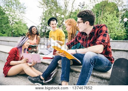 Multi-ethnic group of students stdying together outdoors in a college campus
