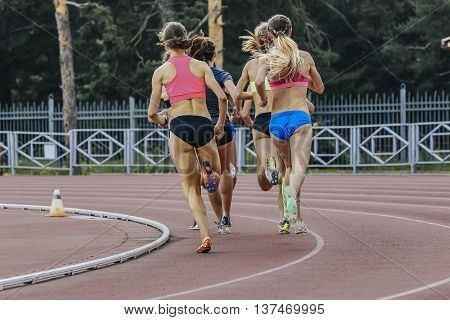 group of women athletes running in stadium during athletics competitions