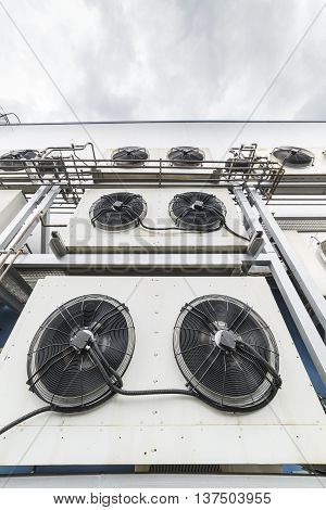 Industrial air conditioning units. A plurality of cooling units installed in the wall of a building.