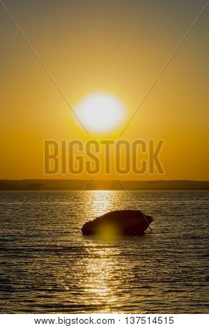 Boat on Siutghiol  lake at sunset .