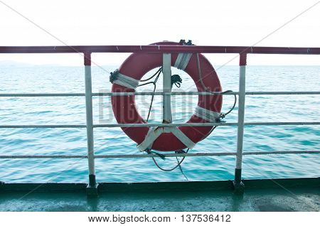 lifebuoy hanging on metal fence of the boat with seascape background