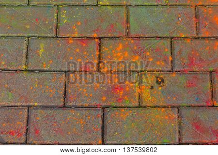 Background of colorful Holi powder in multiple colors lying scattered on the ground.