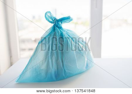 waste recycling, reuse, garbage disposal, environment and ecology concept - close up of rubbish bag with trash or garbage at home