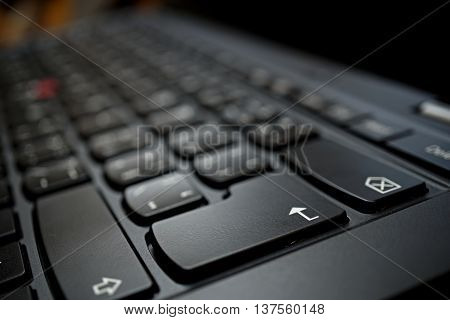 Detail of a brand new modern black laptop keyboard with the focus on the Enter key