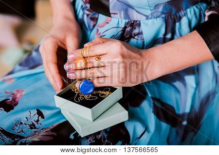 Woman showing beautiful Jewelry necklace with enamel Jewelry. closeup hands. Concept of luxurious and wealth life