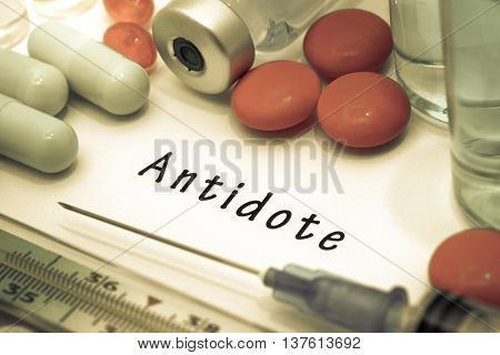 Antidote - diagnosis written on a white piece of paper. Syringe and vaccine with drugs.
