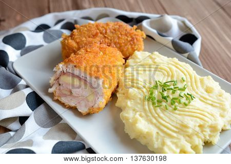Traditional Cordon bleu with mashed potatoes on a wooden background