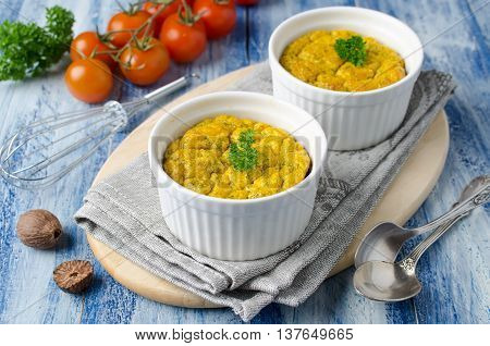 French baked cheese souffle with carrots and dill in white ramekin. Delicious and healthy Breakfast for the whole family