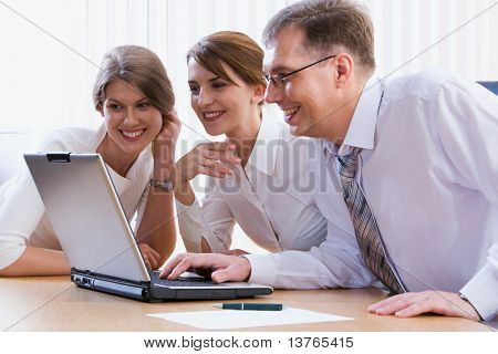 同僚のグループが一緒に興味深い質問を議論するラップトップ周りを収集