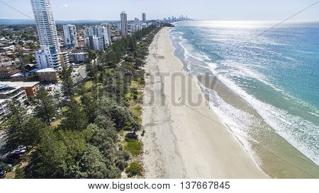 Aerial view of Burleigh beach and surrounds at sunrise, with morning sun rise glistening off the ocean. Gold Coast, Australia