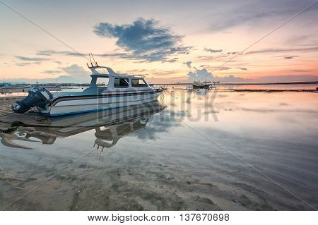 Holiday in Bali, Indonesia - Reflection Sunrise in Tanjong Benoa with boat