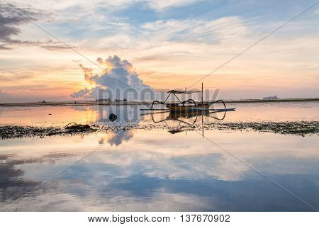 Holiday in Bali, Indonesia - Reflection Sunrise in Tanjong Benoa with boat