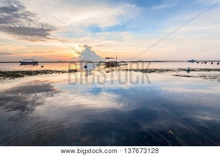 Holiday in Bali, Indonesia - Reflection Sunrise in Tanjong Benoa with boat