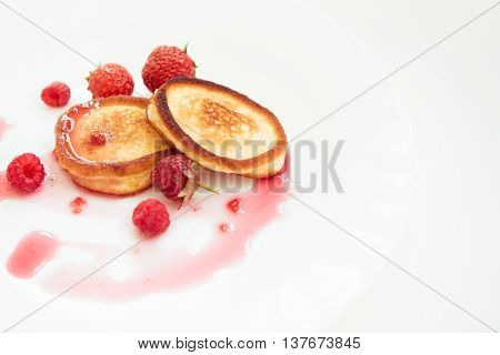 Pancakes on the white plate with raspberry jam
