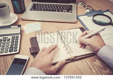 Image of business hands with pen over business document in working environment