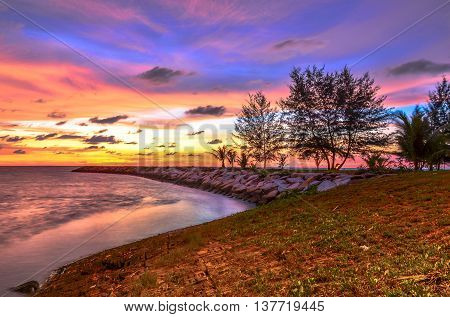 Amazing twilight sunset over tropical island with colourful sky cloudy and tropical tree beach at Labuan Pearl of Borneo.