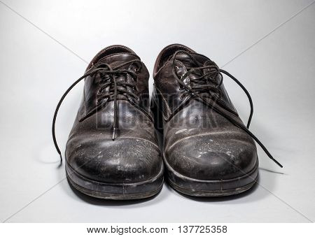 Dirty men's shoes sprinkled with whitewash. Shoes on a white background.