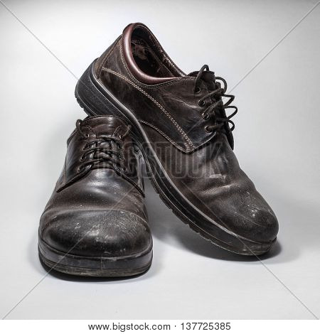 Dirty men's shoes sprinkled with whitewash. Shoes on a white background.