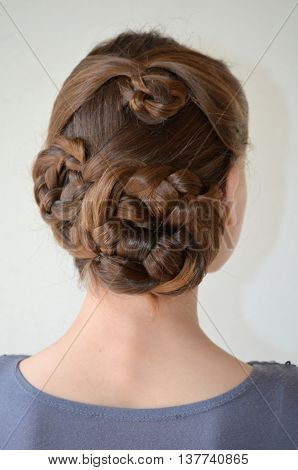 Weaving with long hair - young girl in blue on a white background