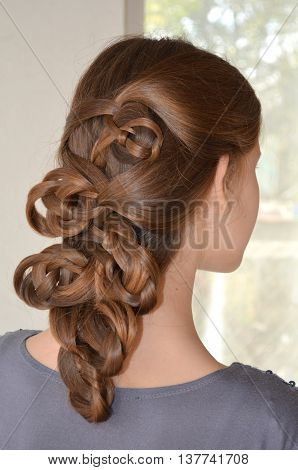 Weaving with long hair - young girl in blue on a white background
