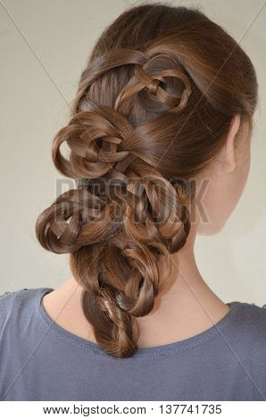 Weaving with long hair - young girl in blue on a white background