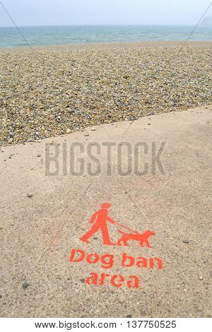 Red painted sign for Dog ban area on Jurassic Coast in coastal town Seaton Devon